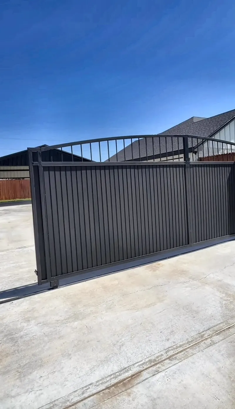 Black metal sliding driveway gate with arched top